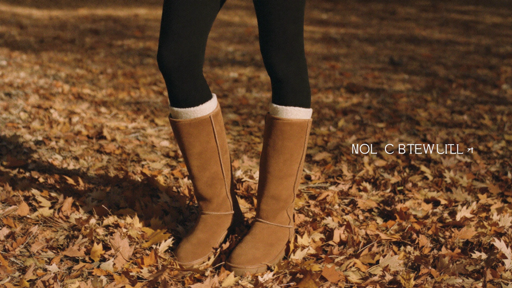 Tall tan shearling boots on autumn leaves