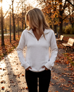 Woman on an autumn park path in a quarter zip V-neck knit sweater