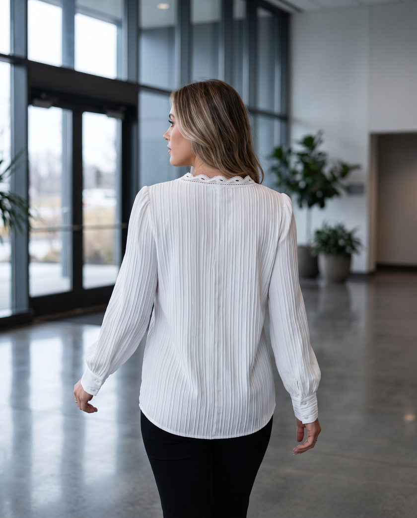 Woman walking through an office lobby in a tailored long sleeve pull-on blouse