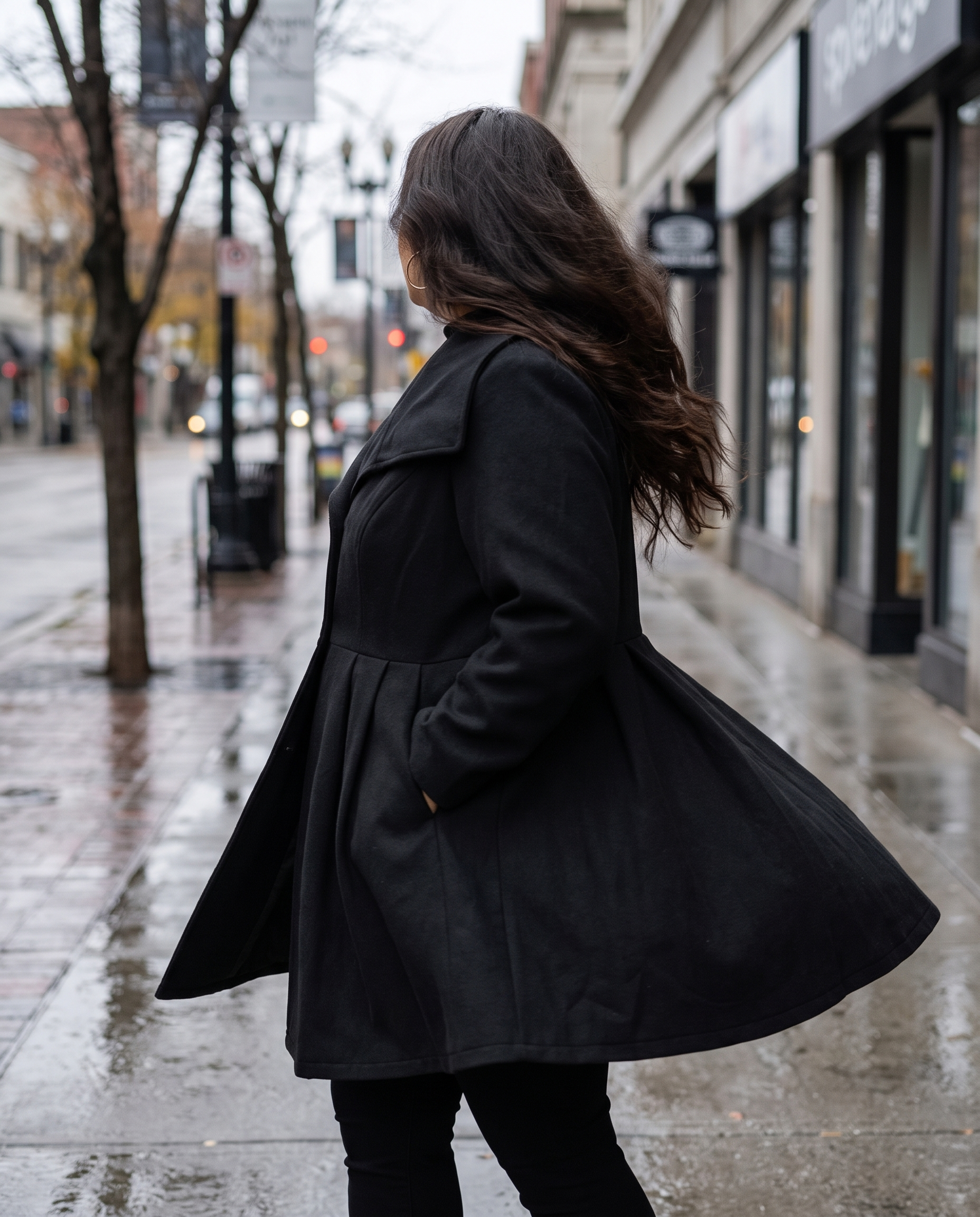 Plus size woman walking a city sidewalk in an asymmetrical lapel button-up coat