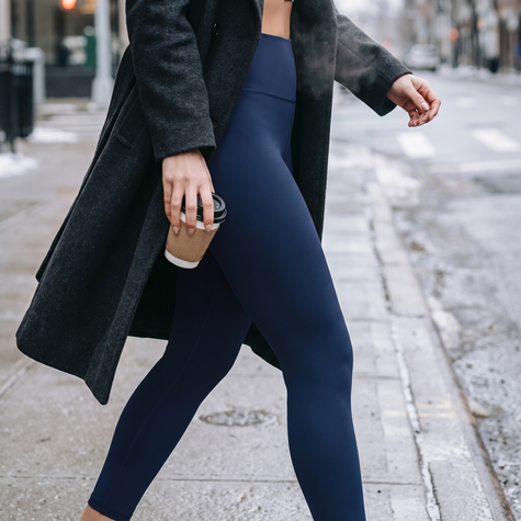 Solid navy fleece lined thermal leggings worn walking on a cold city sidewalk