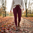 Solid wine red fleece lined leggings worn walking a leaf covered autumn park path