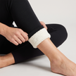 Black leggings with the ankle cuff rolled inside out by hand to show the thermal fleece lining