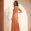 Orange floral one shoulder maxi dress shown from behind over the bare shoulder