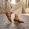 v2 Cognac woven Mary Jane flats walking on a cobblestone street