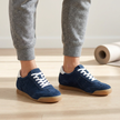 v2 Navy Tock suede sneakers on a studio wood floor