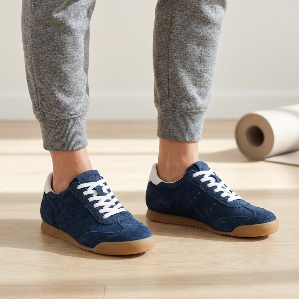 v2 Navy Tock suede sneakers on a studio wood floor