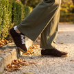 v2 Brown Tock suede sneakers on a gravel park path