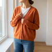 Soft knit cardigan wrapped closed in warm window light