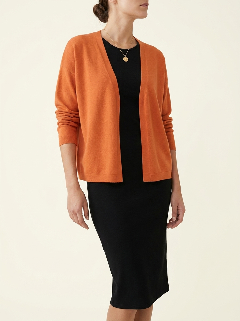Soft knit cardigan layered over a black midi dress