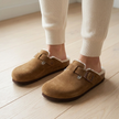 Brown fur lined cork footbed clogs worn on oak floorboards