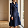 Navy tailored coat dress worn beside a sunlit window