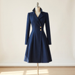 Navy tailored coat dress with structured collar and button placket on a studio form