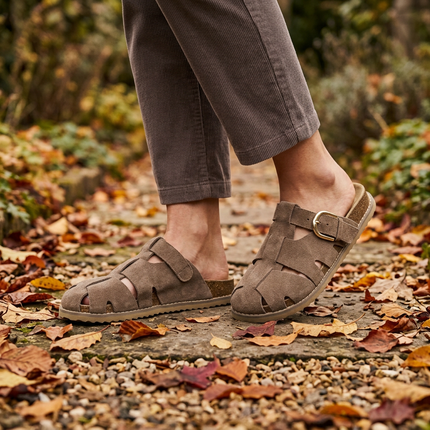 Womens buckle clogs walking a garden path scattered with leaves