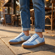 Lace up sneakers for women worn with cuffed jeans on a sunlit city sidewalk