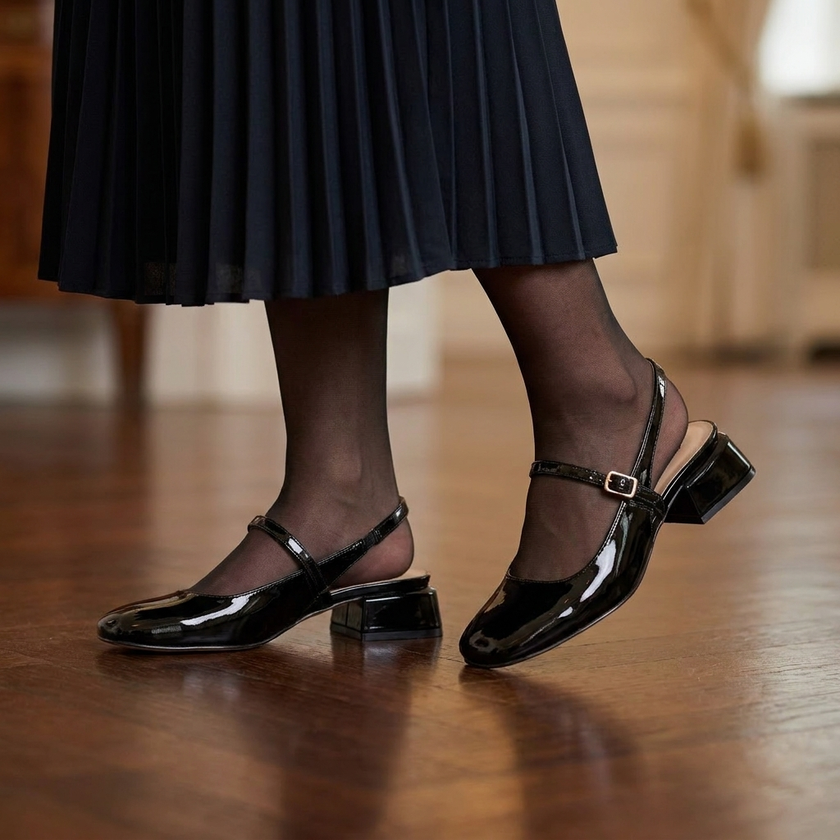 Mary jane block heel shoes worn with tights and a pleated midi skirt