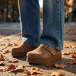 Platform clogs for women worn with wide leg jeans on an autumn sidewalk
