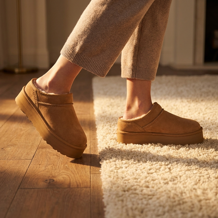 Womens cozy platform clogs stepping onto a wood floor