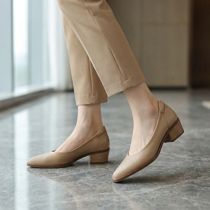 Pointed toe block heel pumps for women worn with tailored trousers on a stone floor