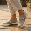 Mesh slip on sneakers for women worn with cropped trousers on a wooden deck