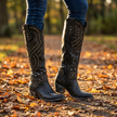 Knee high boots for women worn over slim jeans on an autumn park path