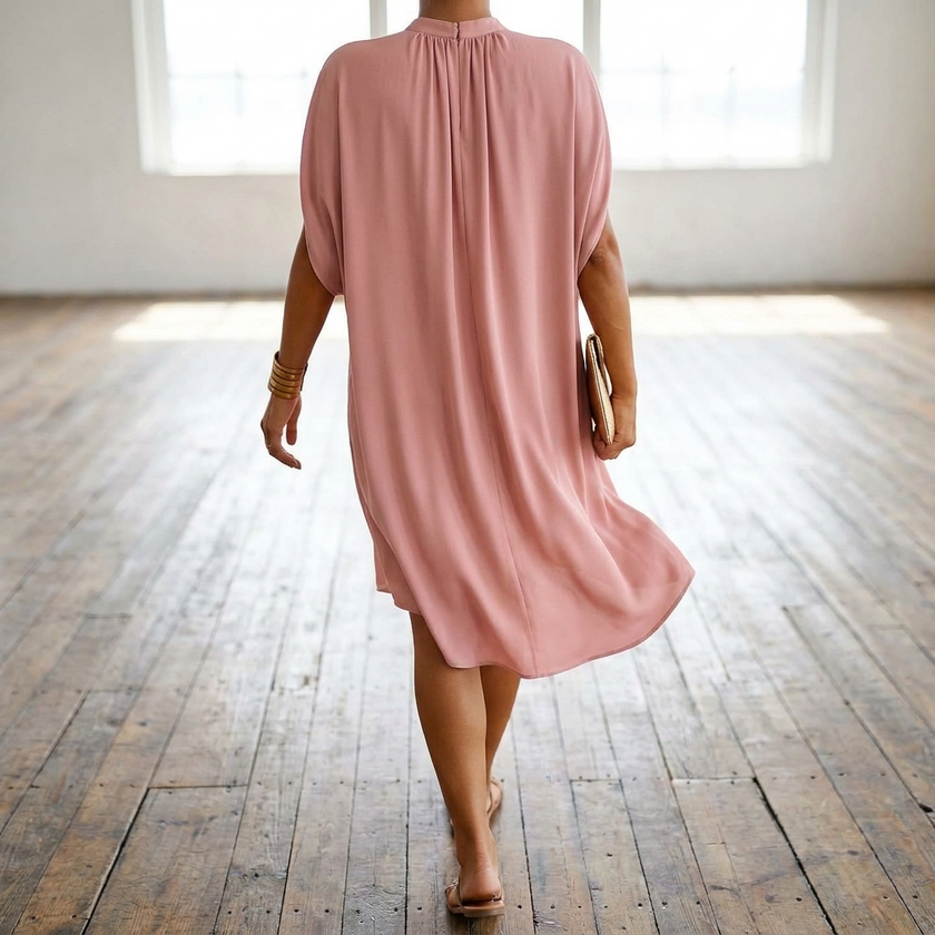Womens batwing sleeve midi dress seen from behind walking toward a window