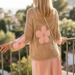 Womens floral crochet knit top seen from behind at a balcony rail