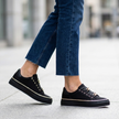 Woman walking in white platform sneakers with gold chain detail