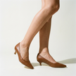 Women's kitten heel pumps worn on a clean pale studio floor in crisp light