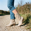 Comfort boots for women standing on a gravel country lane in autumn daylight