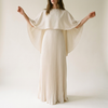 Pleated cape sleeve maxi dress for women, studio backdrop, arms lifted showing the cape drape