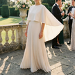 Pleated cape sleeve maxi dress for women on a stone terrace at a formal garden wedding
