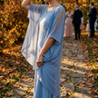 Sheer sleeve midi dress for women on a leaf-strewn stone path at an autumn wedding