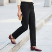 Black pull-on straight-leg trousers with drawstring waist, worn with burgundy Mary Jane flats on a city sidewalk