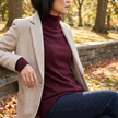 Thea burgundy turtleneck sweater layered under an open wool blazer