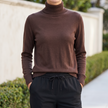 Thea brown fine knit turtleneck sweater tucked into straight-leg trousers
