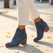 Arch support cutout boots walking on a sunlit sidewalk with fall leaves