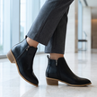 Arch support ankle boots with side zip in a modern lobby with tailored trousers