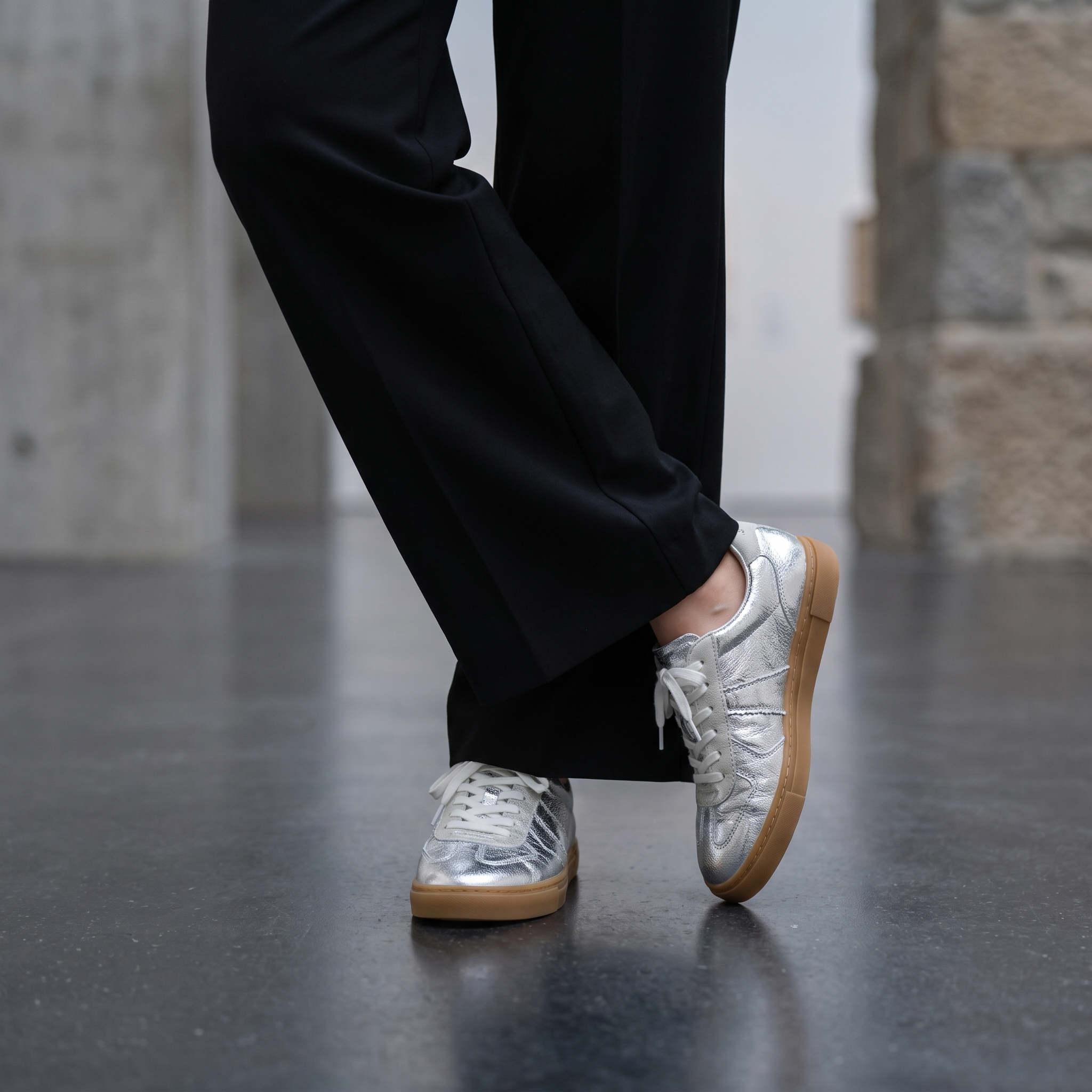 Silver lace up sneakers for women with black wide leg trousers