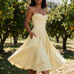 Womens corset midi dress with pockets in yellow, wedding guest A-line dress worn at a citrus orchard garden wedding
