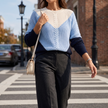 Women's colorblock crew neck sweater in blue, worn with wide leg trousers