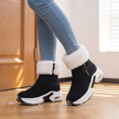 black fur lined winter ankle boots for women in an entryway