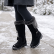 black fur cuff winter boots for women on a snowy sidewalk