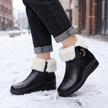 black fleece lined ankle boots for women on a snowy sidewalk