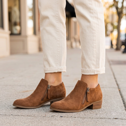 Brown suede zip up ankle boots on a city sidewalk